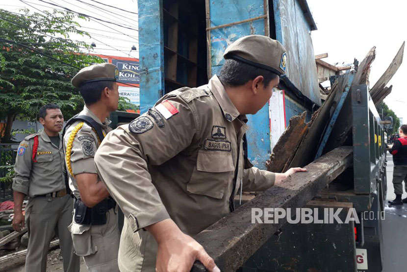 Satuan Polisi Pamong Praja (Satpol PP) Kota Tangerang Selatan tertibkan pedagang kaki lima (PKL) di sepanjang Jalan Raya Serpong, Pakulonan, Serpong Utara, Kota Tangerang Selatan, Jumat (28/4). 