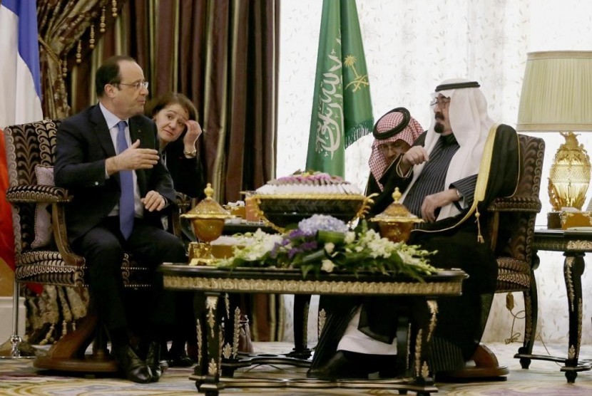 Saudi Arabia's King Abdullah (right) speaks with French President Francois Hollande during their meeting in Riyadh, Saudi Arabia, Sunday, Dec. 29, 2013. 