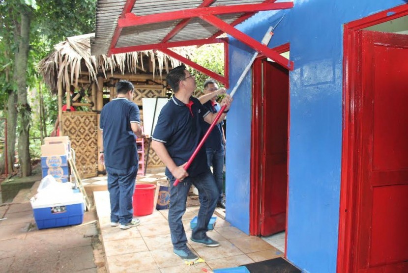 Sebagian dari tim relawan UOB Indonesia saat melakukan pengecatan gedung sekolah Madrasah Ibtidaiah Alam Robbani.   