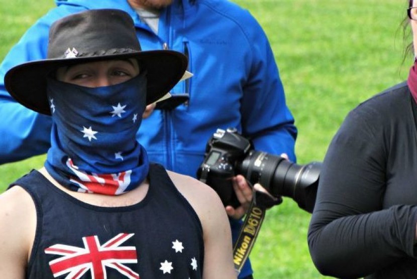 Sebagian demonstran mengenakan bendera Australia menutupi wajahnya. 