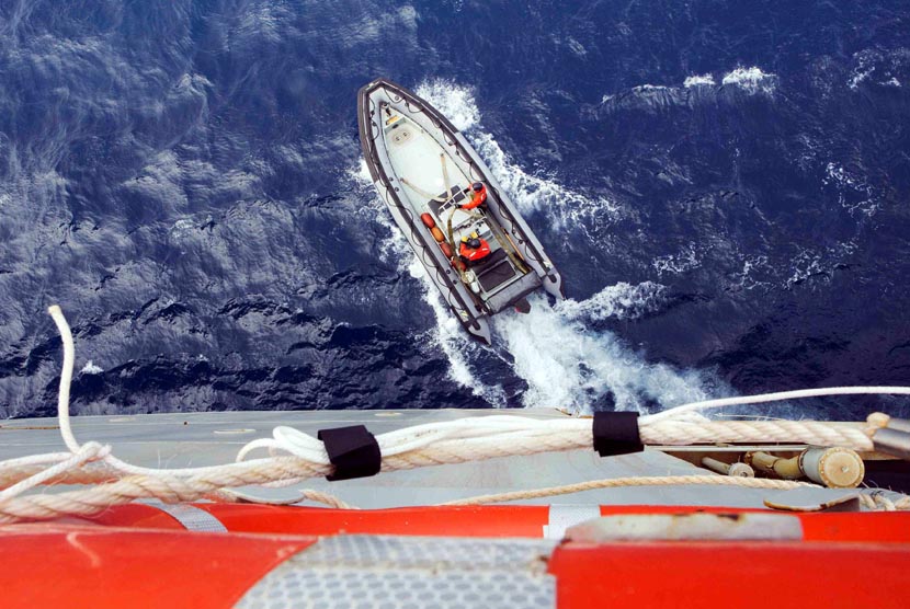 Sebah perahu dari kapal Angkatan Laut Australia HMAS Success, menyelidiki penampakan objek yang diduga berasal dari puing-puing di Samudera Hindia Selatan, Selasa (25/3).  (Reuters)