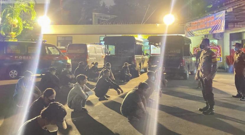 Sebanyak 20 remaja dikumpulkan di halaman Markas Polsek Menteng, Jakarta Pusat, Senin (5/7) malam. Mereka sebelumnya kepadatan nongkrong hingga larut malam saat pemberlakuan PPKM Darurat di Ibu Kota.