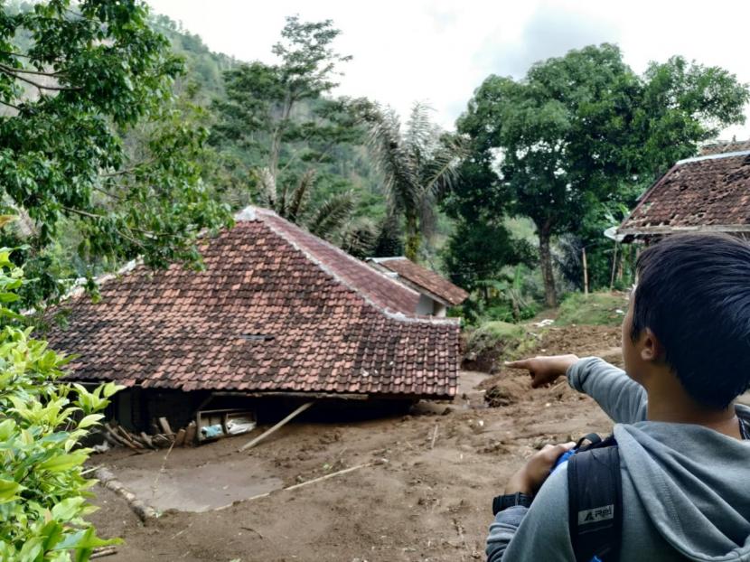 Warga memandangi rumah yang tertutup lumpur akibat longsor (ilustrasi).