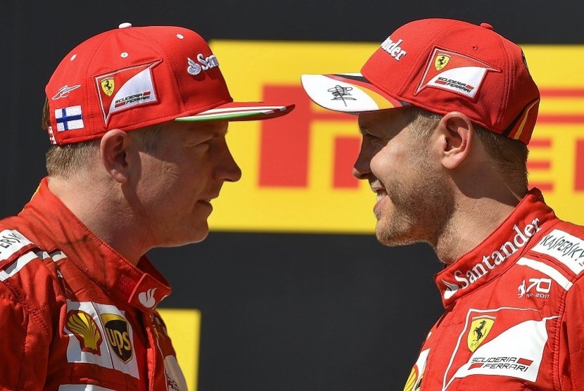 Sebastian Vettel (kanan) bersama rekan setimnya dari Ferrari Kimi Raikkonen setelah menjuarai GP Hungaria, Ahad (30/7).