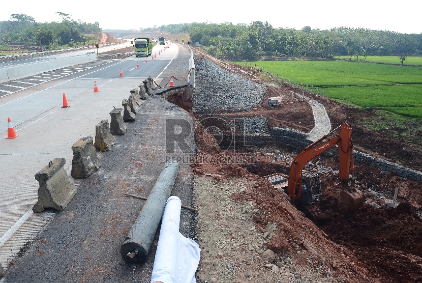 Sebuah alat berat dioperasikan oleh pekerja untuk memperbaiki bahu jembatan di Km 78 Jalan Tol Cipali, Jawa Barat, Jumat (26/6).  (Republika/Raisan Al Farisi)