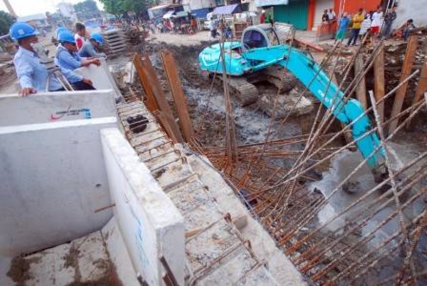 Sebuah alat berat melakukan pengerukan endapan di dasar sungai pada proyek gorong-gorong (box culvert) tahap II kawasan Banyuurip, Surabaya