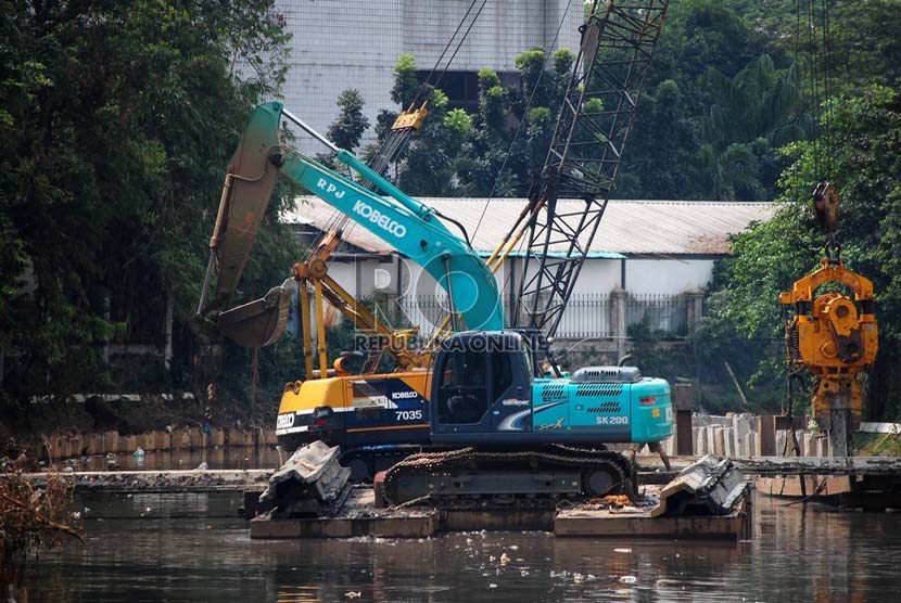 Sebuah alat berat memasang turap di Kali Ciliwung yang berada di Jalan Perwira, Jakarta Pusat, Kamis (3/7).(Republika/Raisan Al Farisi).