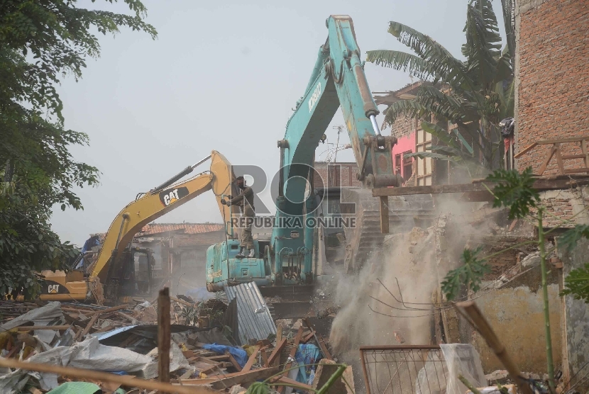 Sebuah alat berat merobohkan sejumlah bangunan permukiman padat di bantaran sungai Ciliwung di Kampung Pulo, Kampung Melayu, Jatinegara, Jakarta, Jumat (21/8).