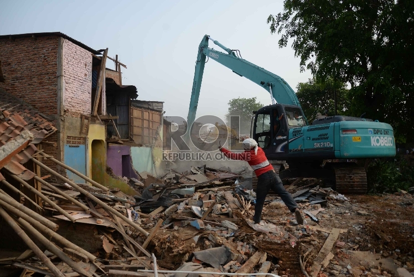 Sebuah alat berat merobohkan sejumlah bangunan permukiman padat di bantaran sungai Ciliwung di Kampung Pulo, Kampung Melayu, Jatinegara, Jakarta, Jumat (21/8). 