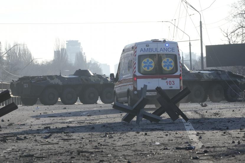 Sebuah ambulans diparkir di dekat barikade dan kendaraan lapis baja Ukraina di sebuah jalan di Kyiv, Ukraina, Sabtu, 26 Februari 2022. Pasukan Rusia menyerbu ke arah ibukota Ukraina Sabtu, dan pertempuran jalanan pecah saat pejabat kota mendesak penduduk untuk berlindung.