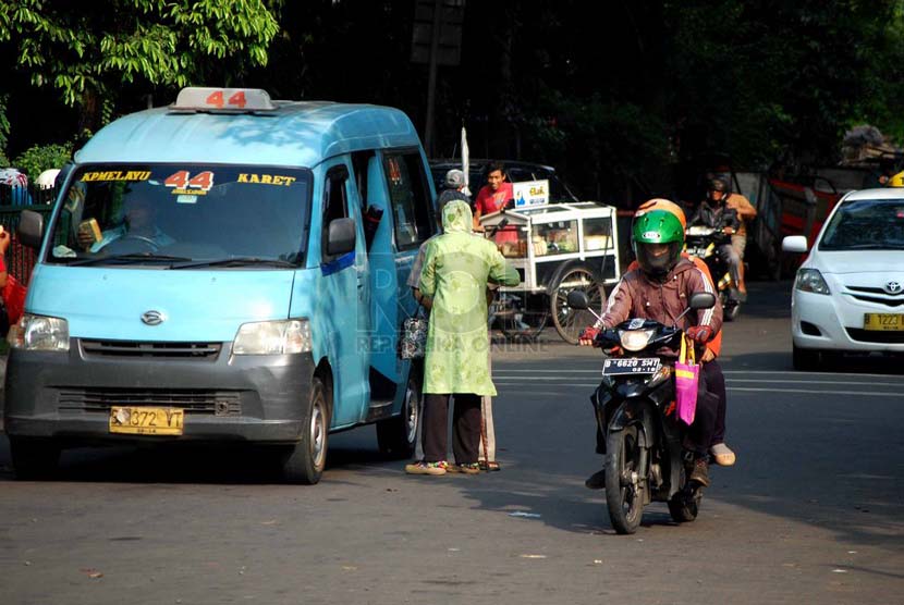 Sebuah angkot jurusan Kampung Melayu - Karet menurunkan penumpang di sembarangan di kawasan Tebet, Jakarta Selatan, Senin (23/6).