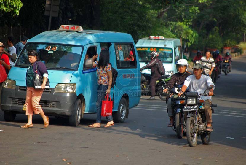 Sebuah angkot jurusan Kampung Melayu - Karet menurunkan penumpang di sembarangan di kawasan Tebet, Jakarta Selatan, Senin (23/6).