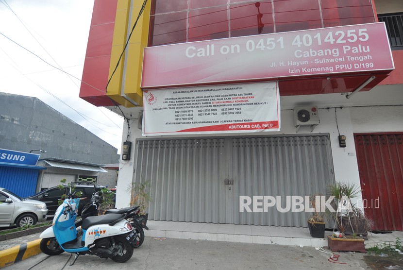 Sebuah baliho bertuliskan kantor diistirahatkan sementara waktu sampai situasi kembali kondusif yang ditujukan kepada seluruh anggota jamaah, agen serta mitra, terpasang di depan Kantor Abu Tours Cabang Palu di Jalan H Hayun Palu, Sulawesi Tengah. 