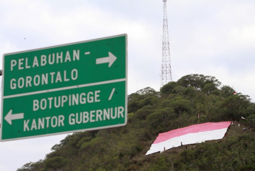 Sebuah bendera merah putih raksasa berukuran 30x30 meter dibentangkan di bukit Dumbo, Kota Gorontalo, Selasa (16/8). 