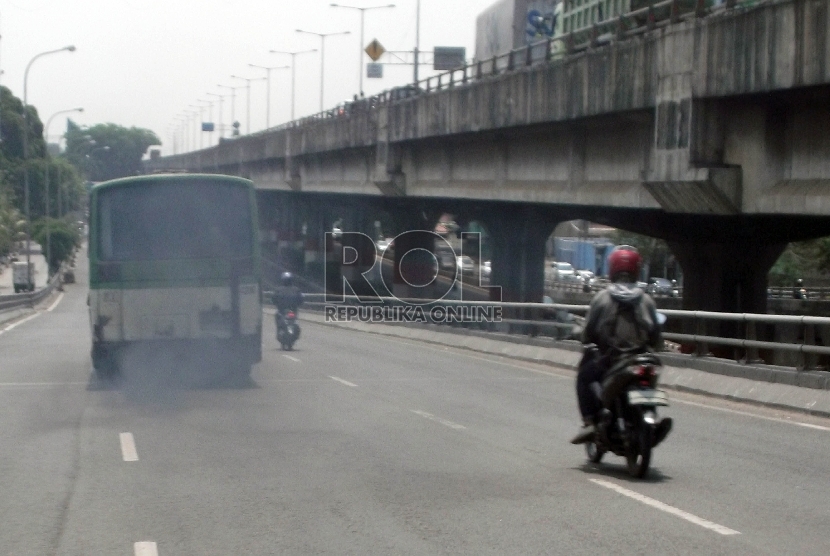   Sebuah bus kota dengan asap mengebul dari knalpotnya melintas di ruas jalan fly over Rawamangun Jakarta, Senin (9/11).