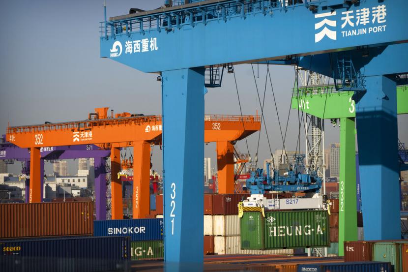Sebuah derek mengangkat peti kemas di pelabuhan peti kemas otomatis di Tianjin, China, Senin, 16 Januari 2023. Aktivitas manufaktur di China secara tak terduga menyusut pada April.