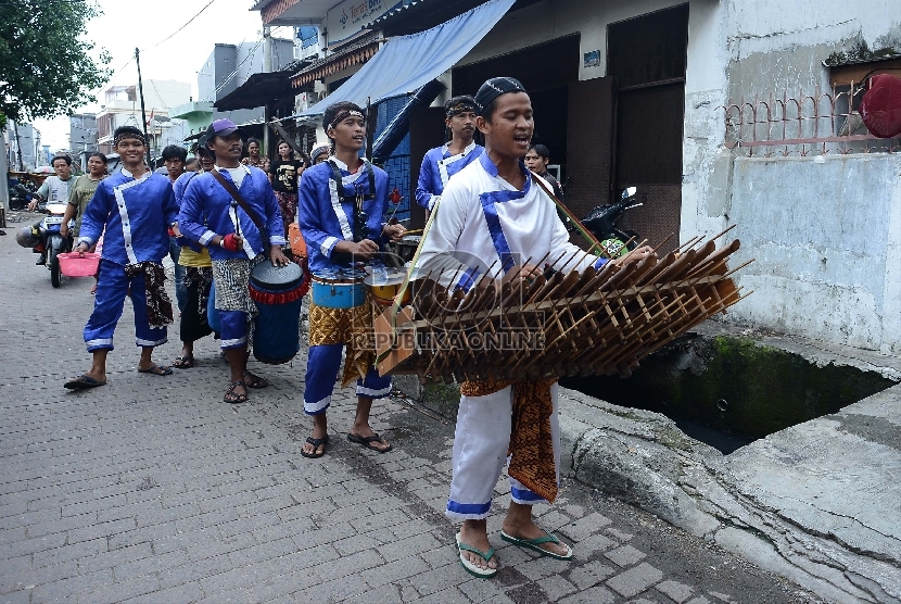 Sebuah grup musik dengan menggunakan alat musik tradisional mengamen di kawasan Glodok, Jakarta Pusat, Rabu (25/2). 