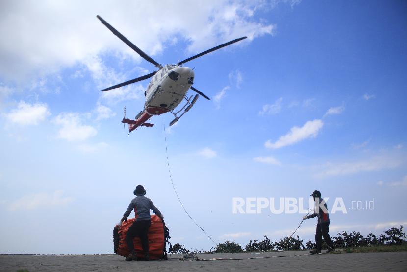 Sebuah helikopter dari BNPB lepas landas dari lapangan milik warga untuk melakukan 