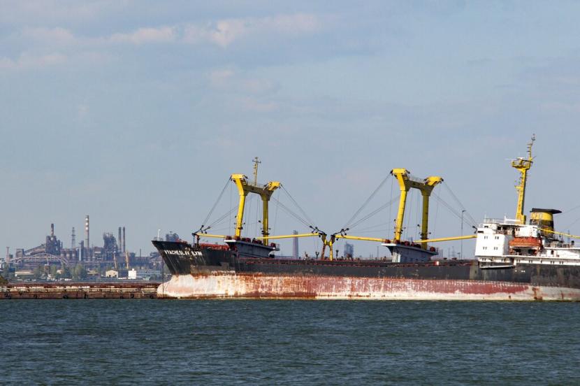 Sebuah kapal kargo kering di Pelabuhan Laut Mariupol di Mariupol, di wilayah di bawah pemerintahan Republik Rakyat Donetsk, Ukraina timur, Jumat, 27 Mei 2022 dengan Metallurgical Combine Azovstal di latar belakang.
