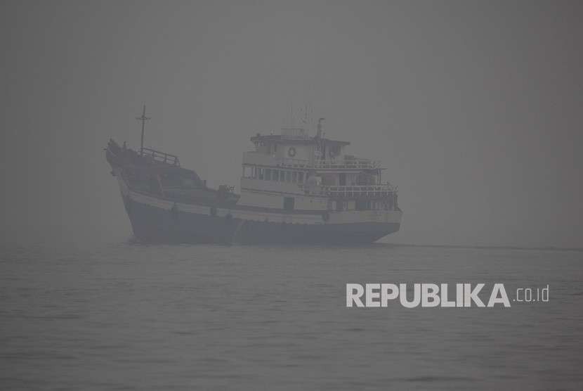 Sebuah kapal niaga melintas di perairan Dumai yang diselimuti kabut asap kebakaran hutan dan lahan di kota Dumai, Dumai, Riau, Rabu (29/8).