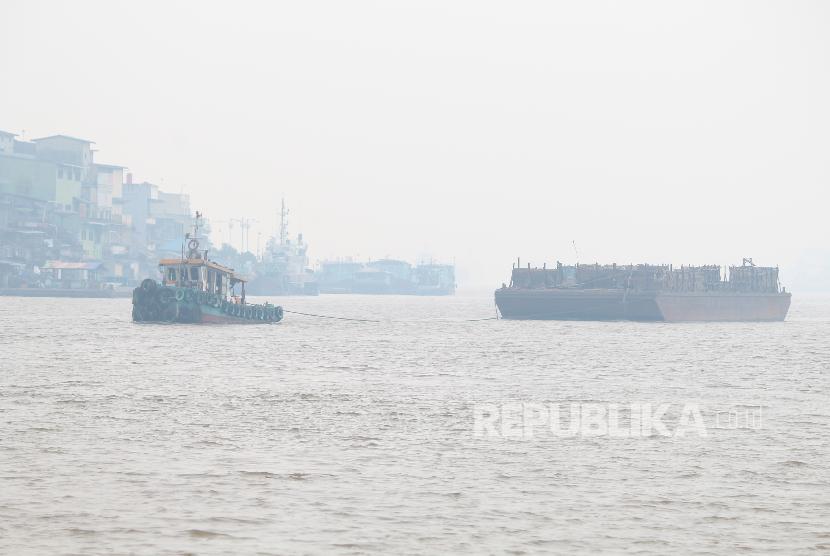 Sebuah kapal pembawa pasir melintasi Sungai Kapuas yang diselimuti kabut asap pekat di Pontianak, Kalimantan Barat.