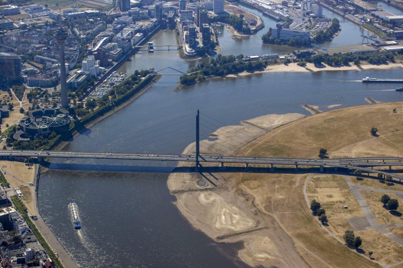 Sebuah kapal pengangkut melewati Rheinturm (Menara Rhine) di Duesseldorf, Jerman, Jumat, 12 Agustus 2022. Menteri Lingkungan Jerman Steffi Lemke mengatakan pada Ahad (14/8/2022), kematian massal ikan di Sungai Oder adalah bencana ekologis. 