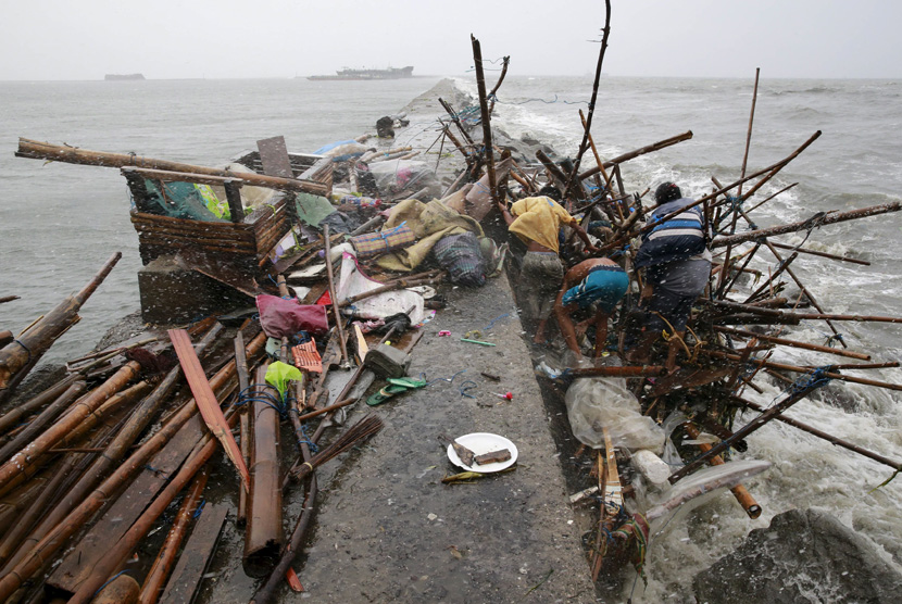 Sebuah keluarga Taroyo yang tinggal di sepanjang pantai Manila Bay mencari item diselamatkan setelah rumah mereka rusak oleh angin kencang yang dibawa oleh topan Koppu pada 18 Oktober 2015. ( REUTERS/Romeo Ranoco )