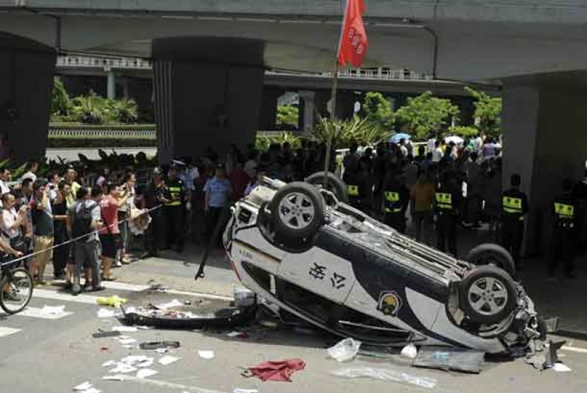   Sebuah kendaraan polisi merk Honda dirusak massa dalam aksi unjuk rasa anti Jepang di Shenzen, Cina, Ahad (19/8). 
