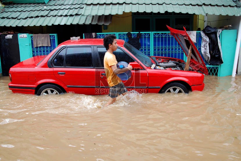  Sebuah kendaraan terendam air di Kampung Poncol, Kelurahan Bukit Duri, Kecamatan Tebet, Jakarta Selatan, Senin (24/12). (Republika/Prayogi)