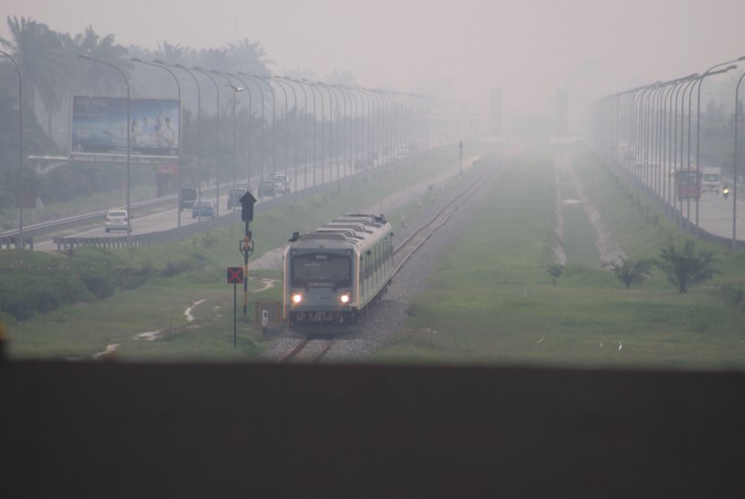  Sebuah kereta api Railink menembus kabut asap saat melintas di Bandara Internasional Kualanamu Kabupaten Deli Serdang, Sumut, Jumat (19/9).   (Antara/Septianda Perdana)