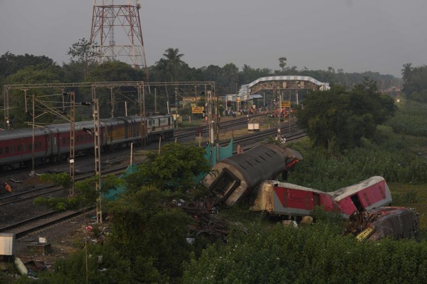 Sebuah kereta penumpang melewati lokasi di mana dua kereta penumpang anjlok pada Jumat di distrik Balasore, di negara bagian Orissa, India timur, Senin, 5 Juni 2023.