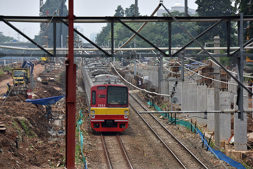 Sebuah Kereta Rel Listrik (KRL) melaju di samping lokasi pembangunan Stasiun Sudirman Baru di Jakarta, Selasa (8/11). 