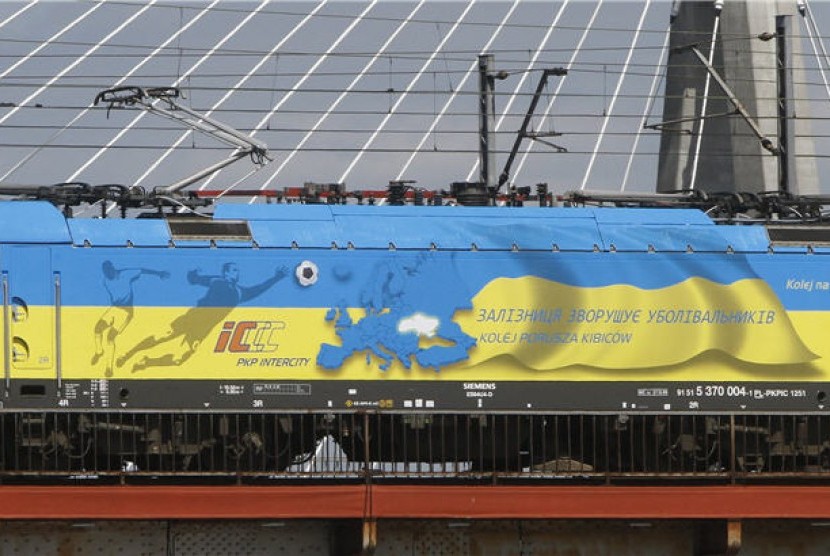Sebuah lokomotif dilukisi dengan warna bendera Ukraina di jembatan di atas Sungai Vistula, Warsawa, Polandia, Sabtu (19/5). 