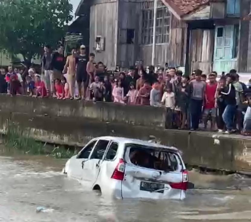 Sebuah mobil Daihatsu Xenia dirusak dan dicemplung warga ke sungai saat terjadi tawuran di Kelurahan 13 Ilir Kota Palembang, Sumatra Selatan, Ahad (13/3/2022). 