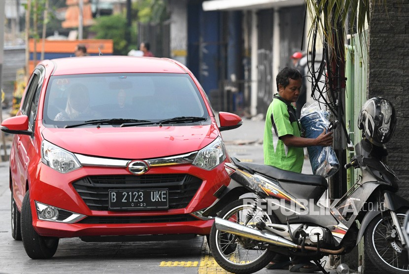 Sebuah mobil dan sepeda motor diparkir di trotoar kawasan Cikini, Jakarta, Selasa (5/11/2019).
