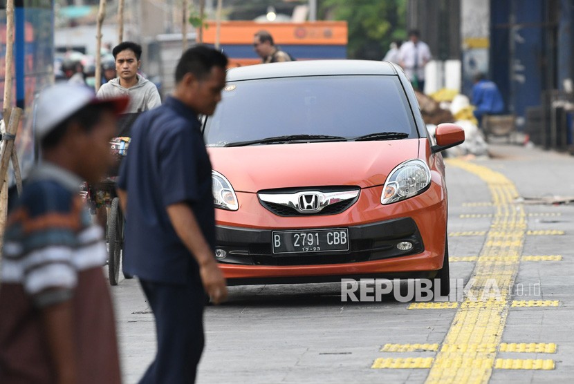  Petugas masih melakukan sosialisasi parkir ganjil genap ke pengemudi mobil di sepanjang Jalan Gajahmada-Hayam Wuruk, Jakarta. Pasalnya, aturan itu mulai berlaku, Jumat (31/1) (Foto: ilustrasi mobil parkir)