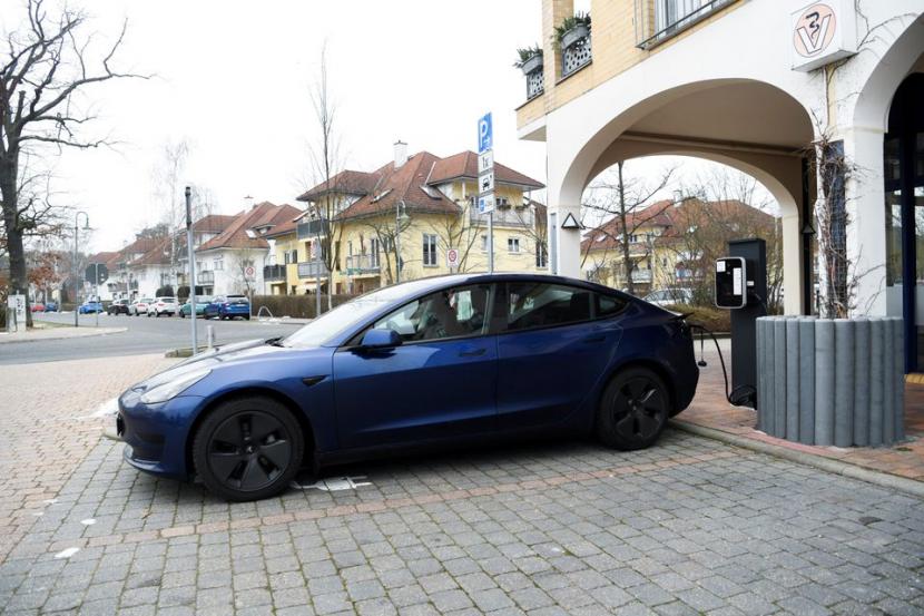 Sebuah mobil listrik Tesla berada di stasiun pengisian daya di pasar di Gruenheide, dekat Berlin, Jerman, 28 Desember 2021. 