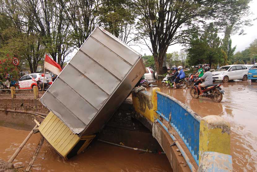 Sebuah mobil masuk ke sungai setelah terseret bajir di depan kantor Walikota Manado, Sulawesi Utara, Kamis (16/1).      (Antara/Fiqman Sunandar)