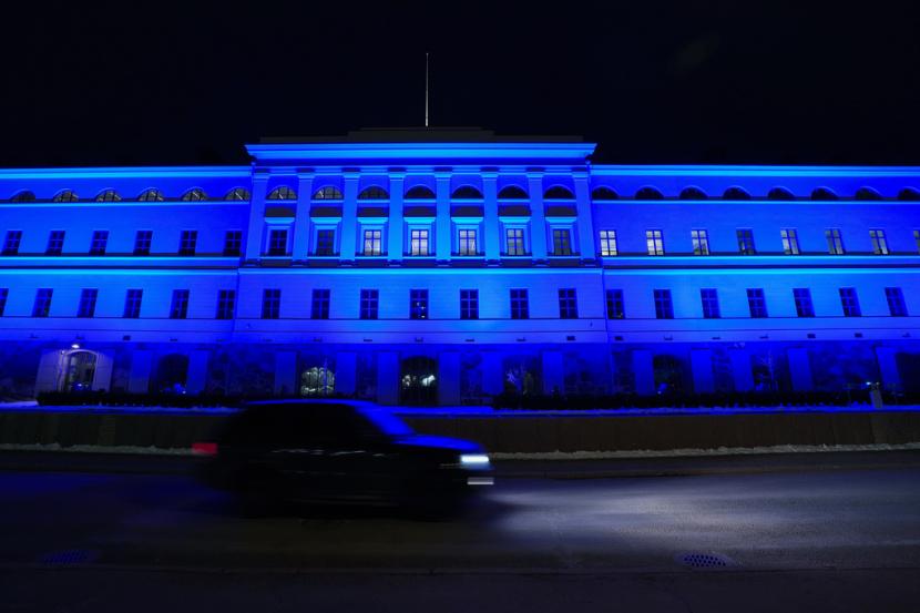 Sebuah mobil melewati gedung Kementerian Luar Negeri yang diterangi dengan warna biru, di Helsinki, Finlandia, Selasa, 4 April 2023. Bendera biru-putih Finlandia berkibar di luar markas NATO Selasa sore, menjadikan Finlandia anggota dan menggandakan perbatasan Rusia dengan NATO. aliansi keamanan terbesar di dunia.
