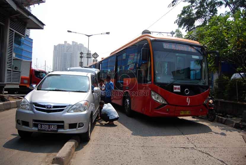  Sebuah mobil minibus tersangkut di pembatas jalur busway Kawasan Jalan Gunung Saharai Raya, Jakarta Utara, Selasa (22/7). (Republika/Raisan Al Farisi)