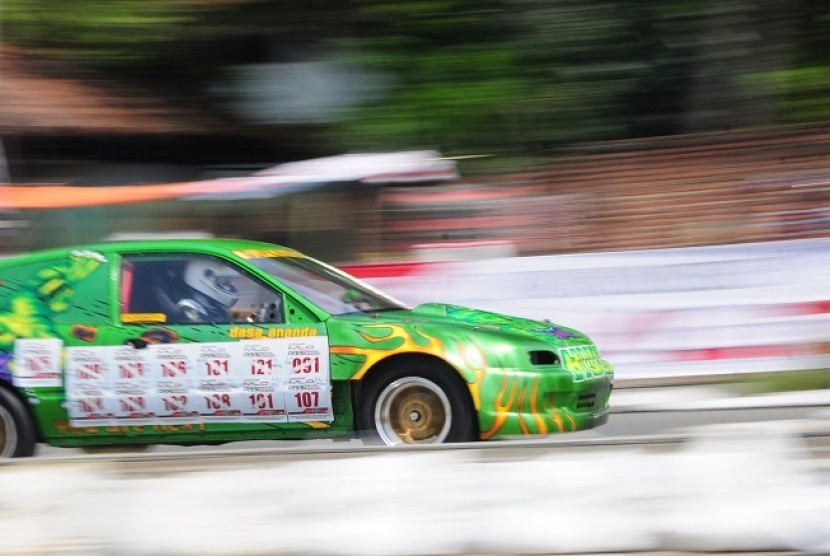Sebuah mobil peserta melaju dengan kecepatan tinggi dalam kejuaraan Drag Race terbuka