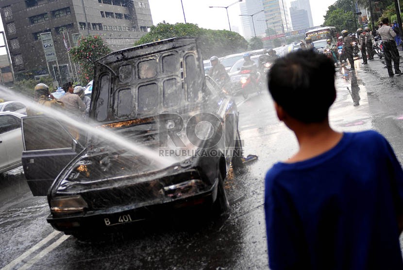  Sebuah mobil sedan terbakar di kawasan Bundaran Hotel Indonesia, Jakarta, Jumat (8/11).  (Republika/Prayogi)