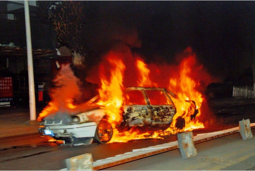 Sebuah mobil terbakar dalam sebuah bentrokan di Xinjiang, Cina.