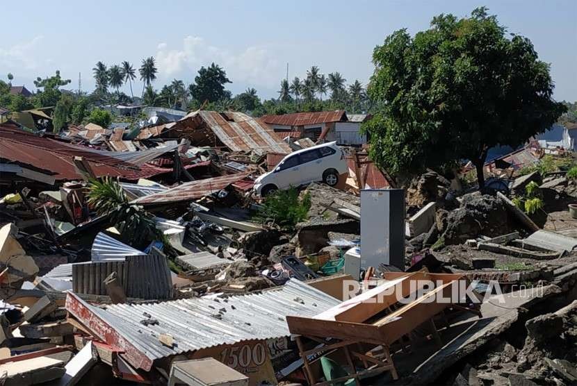 Sebuah mobil terhempas di antara reruntuhan rumah di Perumnas Bala Roa, Palu, Ahad (30/9).