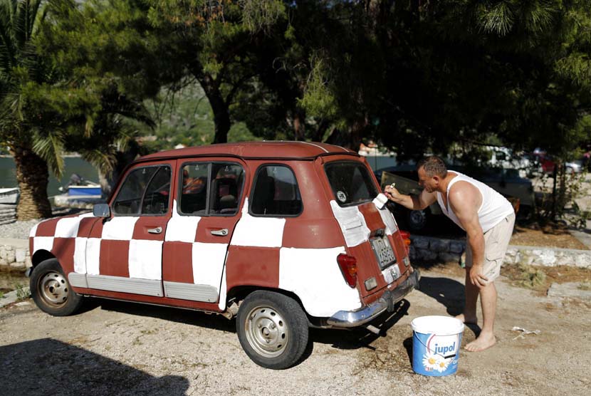 Sebuah penggemar tim sepakbola Kroasia cat mobilnya menyerupai bendera nasional Kroasia di Zaton, selatan Kroasia, Kamis (16/6).   (REUTERS/Antonio Bronic).