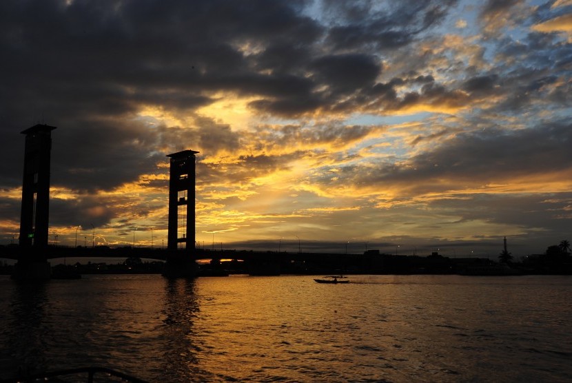 Sebuah perahu melintasi Jembatan Ampera di Palembang, Senin (7/3).