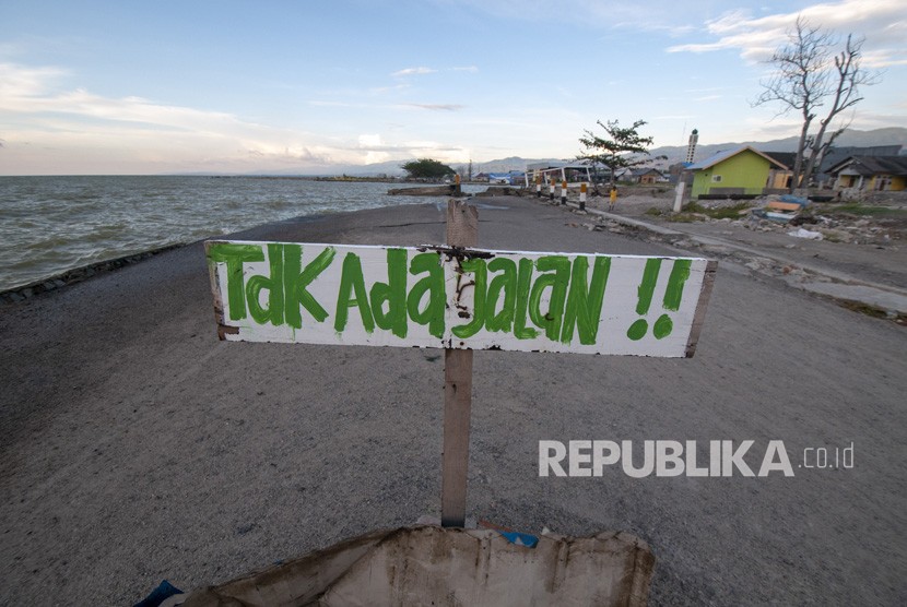 Sebuah peringatan dipasang warga di dekat pantai yang mengalami abrasi pascagempa dan tsunami di Teluk Palu, Sulawesi Tengah, Selasa (19/2/2019).