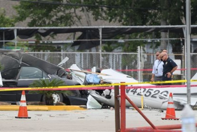 Sebuah pesawat kecil jatuh menimpa sebuah mobil di tempat parkir dekat bandara Houston, Kamis (9/6).