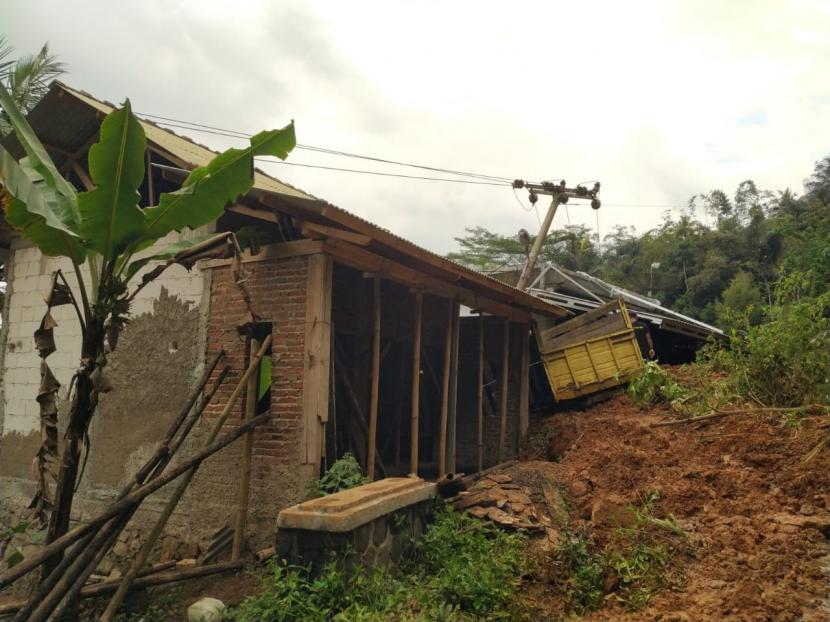 Sebuah rumah dan dua unit mobil di Desa Kawitan, Kecamatan Salopa, Kabupaten Tasikmalaya, tertimpa material tanah longsor, Senin (12/10). 