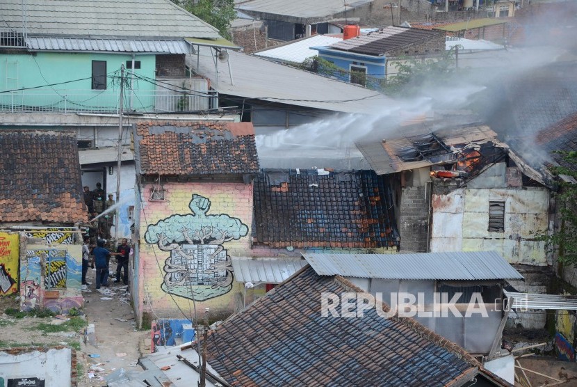 Sebuah rumah terbakar saat penggusuran pemukiman di lahan milik Pemkot Bandung yang akan dijadikan Rumah Deret, di kawasan Tamansari, Kota Bandung, Kamis (12/12).